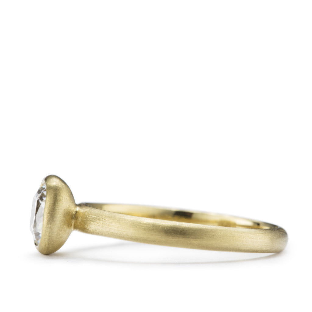 "Chloe" is a soft cushion shaped diamond solitaire engagement ring in brush finished yellow gold.