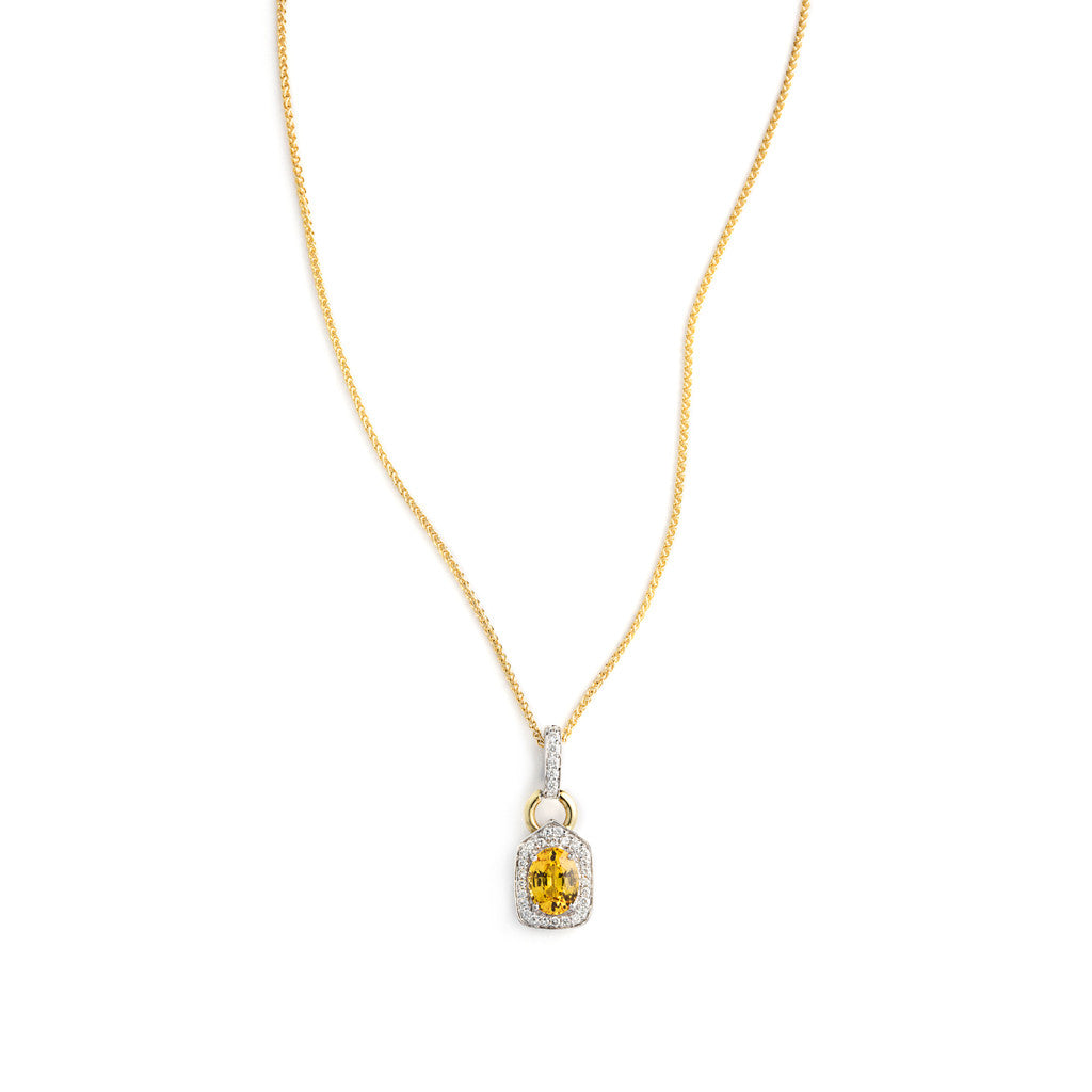 Pendant of Intense Yellow Sapphire set in Yellow Gold and surrounded by Diamonds. 